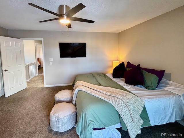 carpeted bedroom featuring a textured ceiling and ceiling fan