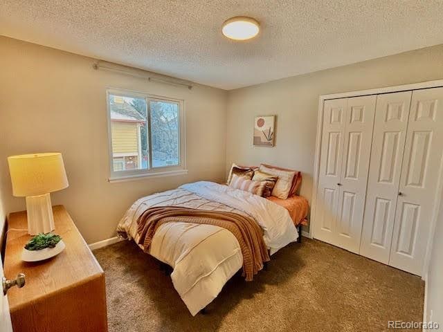 carpeted bedroom featuring a closet and a textured ceiling