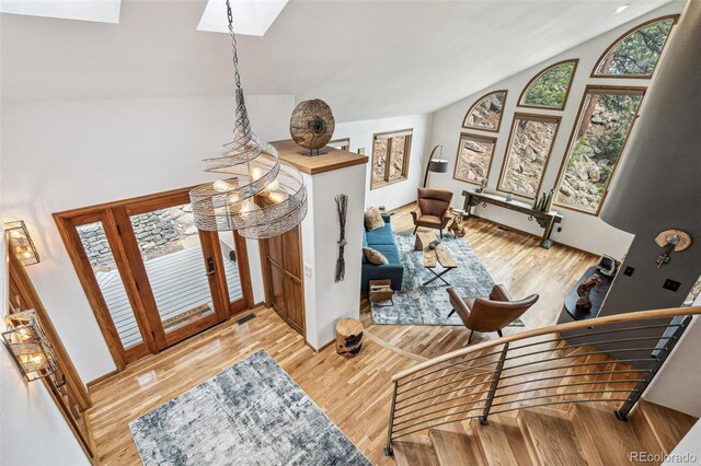 3961 Mossy Rock Ln, Evergreen, CO 80439 - foyer entrance featuring high vaulted ceiling, wood finished floors, and a skylight