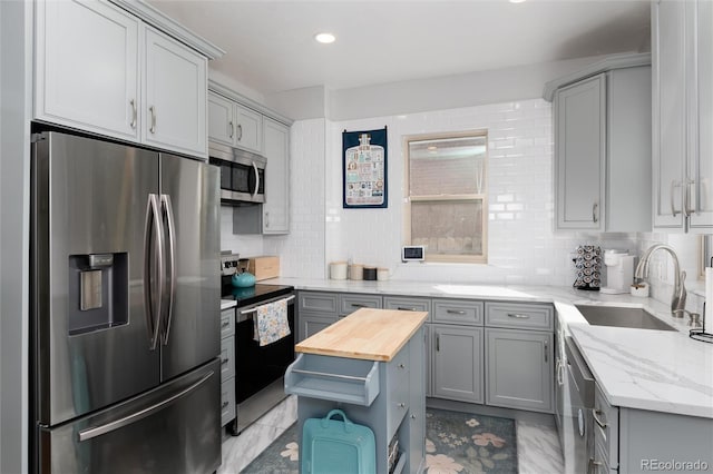 613 S Logan St, Denver, CO 80209 - kitchen featuring appliances with stainless steel finishes, gray cabinets, wood counters, tasteful backsplash, and recessed lighting