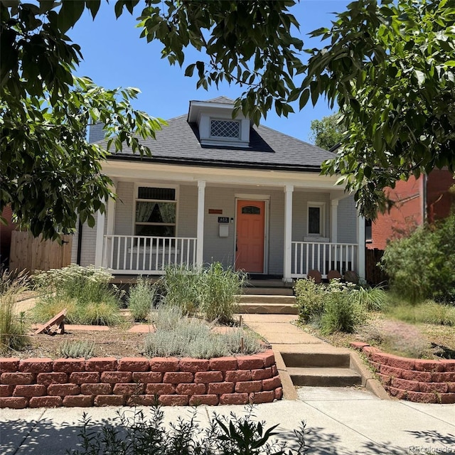 613 S Logan St, Denver, CO 80209 - bungalow-style home featuring covered porch, roof with shingles, and brick siding