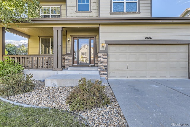 view of exterior entry with covered porch and a garage