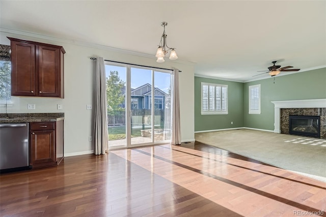 unfurnished living room with a fireplace, hardwood / wood-style floors, ceiling fan with notable chandelier, and ornamental molding