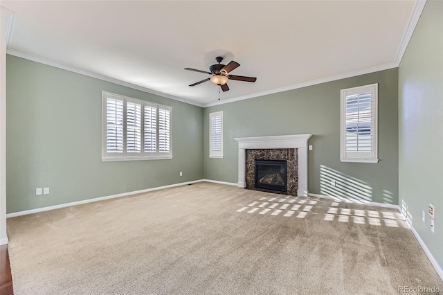 unfurnished living room featuring a wealth of natural light, crown molding, and a high end fireplace