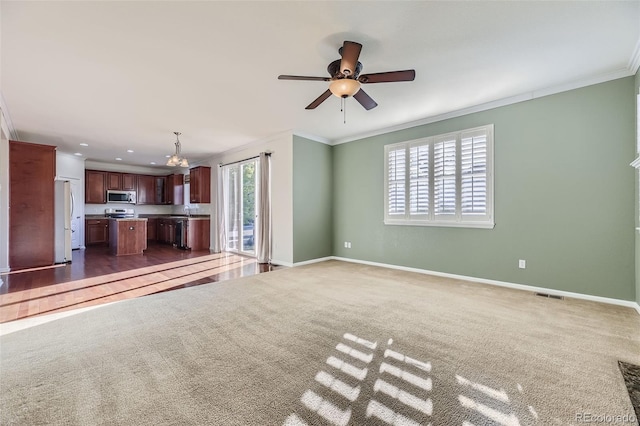 unfurnished living room with dark carpet, a wealth of natural light, and crown molding