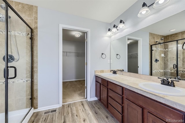 bathroom with hardwood / wood-style flooring, vanity, and walk in shower