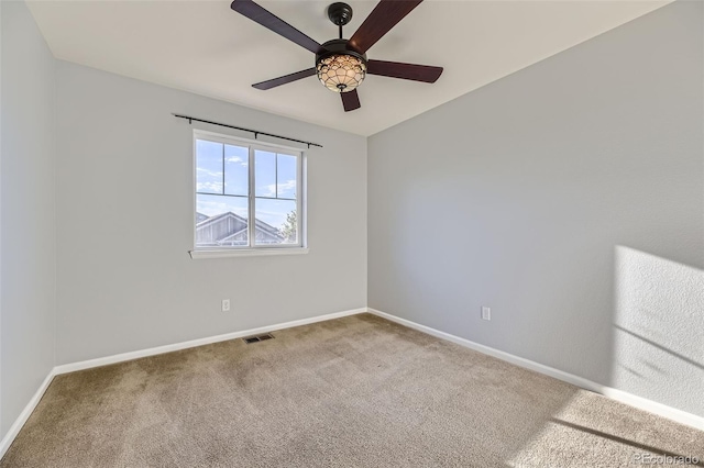 spare room with ceiling fan and carpet