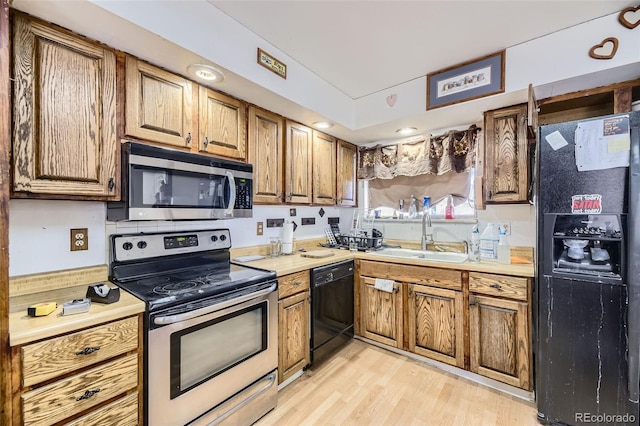 kitchen with sink, light wood-type flooring, and black appliances