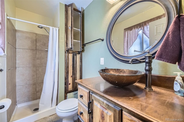 bathroom featuring toilet, a shower with shower curtain, and vanity