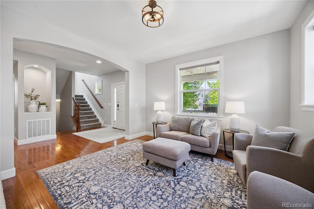 11674 Newton St, Westminster, CO 80031 - living room featuring stairway, arched walkways, and wood finished floors