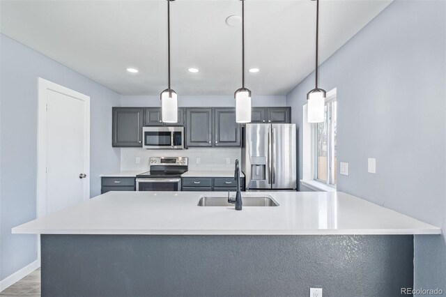 kitchen featuring gray cabinets, appliances with stainless steel finishes, sink, hanging light fixtures, and kitchen peninsula