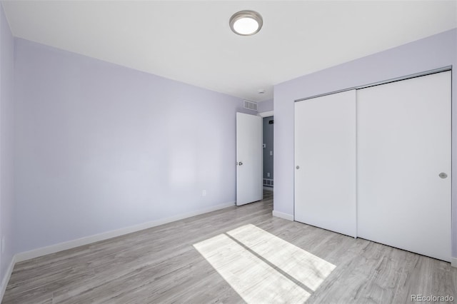 unfurnished bedroom with light hardwood / wood-style flooring and a closet