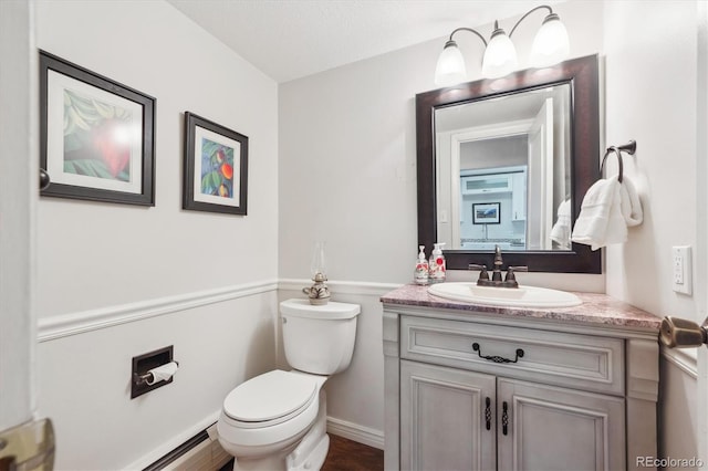 bathroom with vanity, a baseboard heating unit, a textured ceiling, and toilet