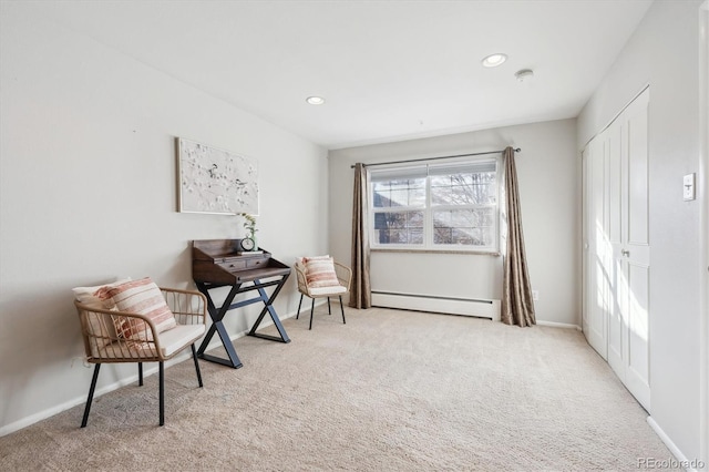 living area featuring light carpet and baseboard heating