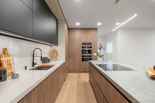 1518 S Columbine St, Denver, CO 80210 - kitchen with modern cabinets, black electric cooktop, a sink, light wood-style floors, and recessed lighting