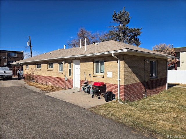 exterior space with brick siding and a front lawn