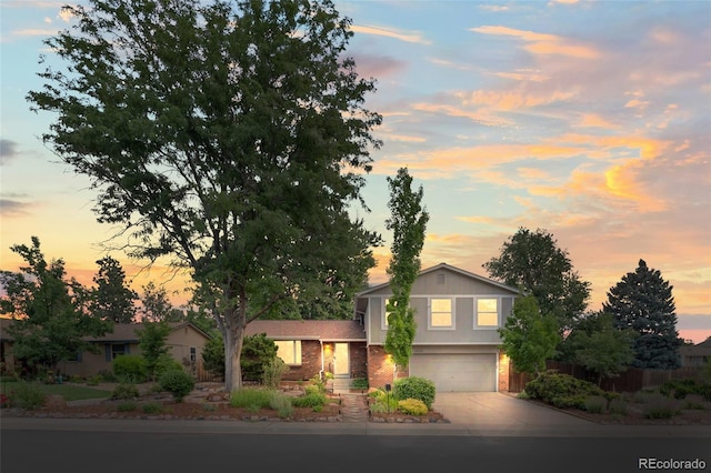 3458 S Norfolk Way, Aurora, CO 80013 - tri-level home featuring concrete driveway, a garage, and brick siding