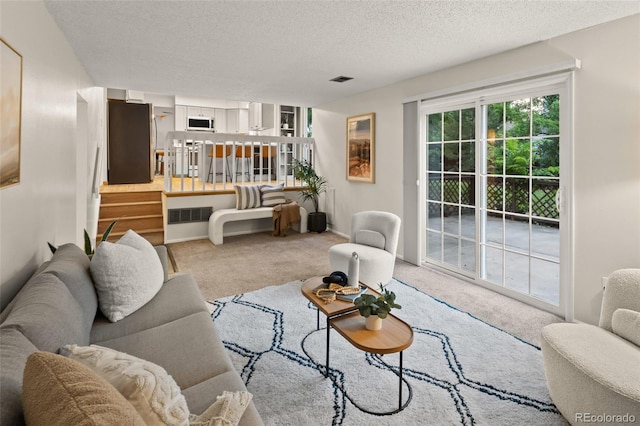 3458 S Norfolk Way, Aurora, CO 80013 - living room featuring carpet floors, a textured ceiling, and stairway