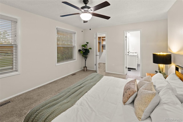 3458 S Norfolk Way, Aurora, CO 80013 - bedroom with carpet, a spacious closet, multiple windows, a ceiling fan, and a textured ceiling