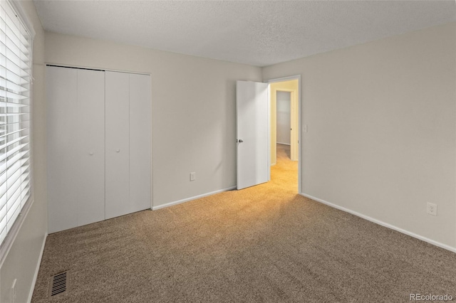 3458 S Norfolk Way, Aurora, CO 80013 - unfurnished bedroom with carpet floors, multiple windows, a closet, and a textured ceiling