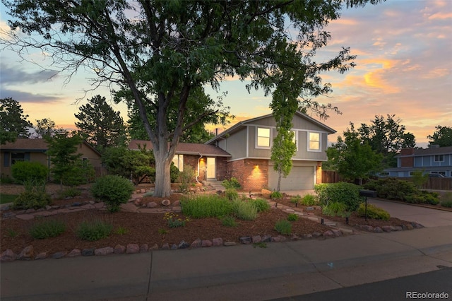 3458 S Norfolk Way, Aurora, CO 80013 - tri-level home with an attached garage, concrete driveway, and brick siding