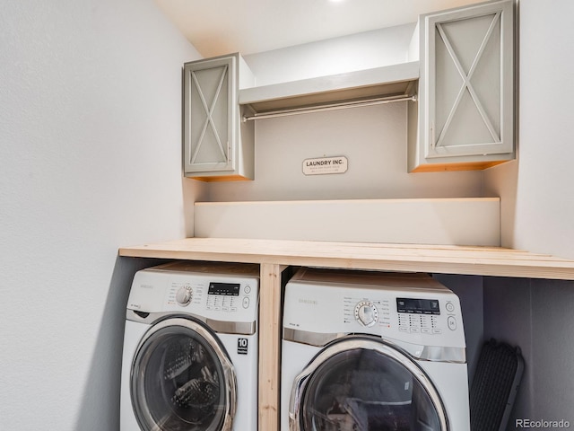 laundry room with washing machine and dryer and cabinets