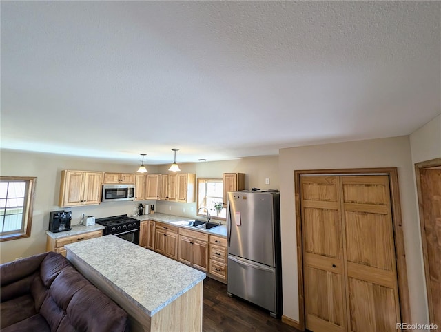 kitchen with a kitchen island, pendant lighting, sink, dark wood-type flooring, and stainless steel appliances