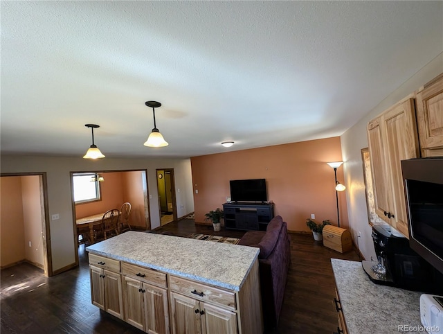 kitchen with dark hardwood / wood-style flooring, light brown cabinets, and decorative light fixtures