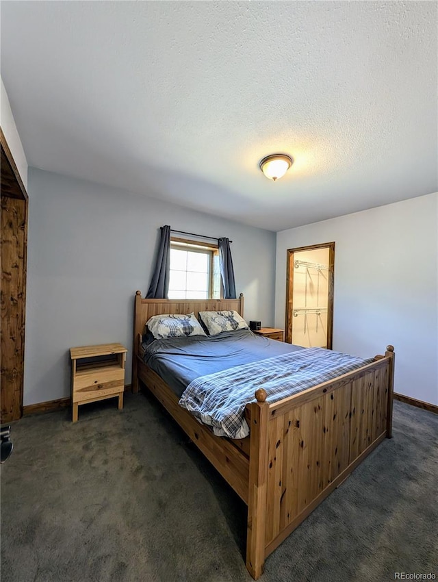 bedroom featuring a textured ceiling, a closet, and dark colored carpet