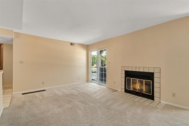 unfurnished living room featuring light carpet and a tile fireplace