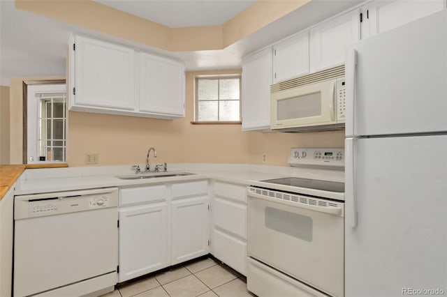 kitchen featuring light tile patterned flooring, white appliances, white cabinetry, and sink