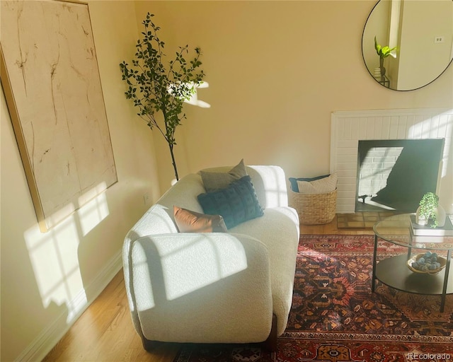 interior space featuring a brick fireplace and hardwood / wood-style flooring