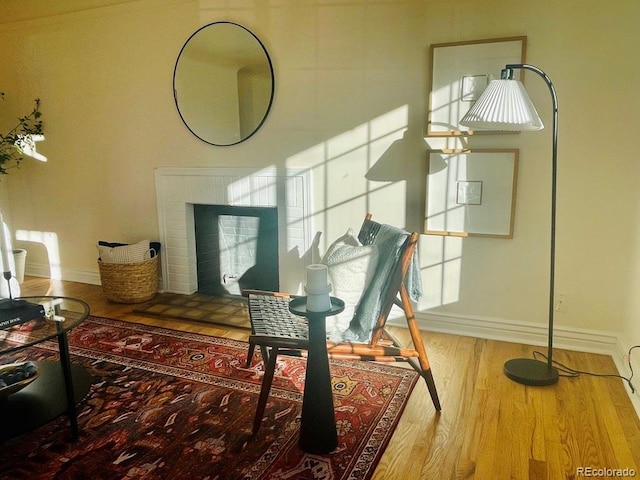 interior space with a brick fireplace and hardwood / wood-style floors