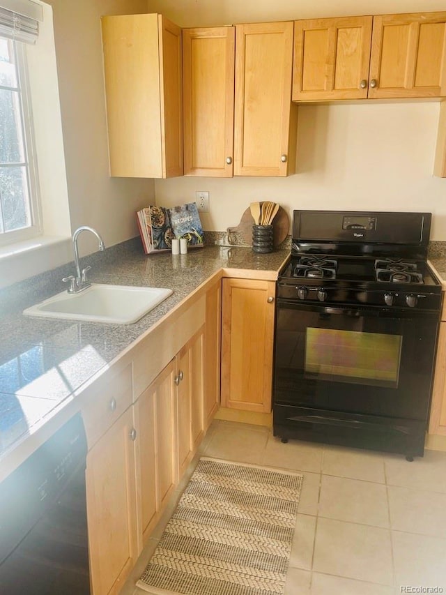 kitchen featuring black appliances, light tile patterned floors, sink, and light brown cabinets