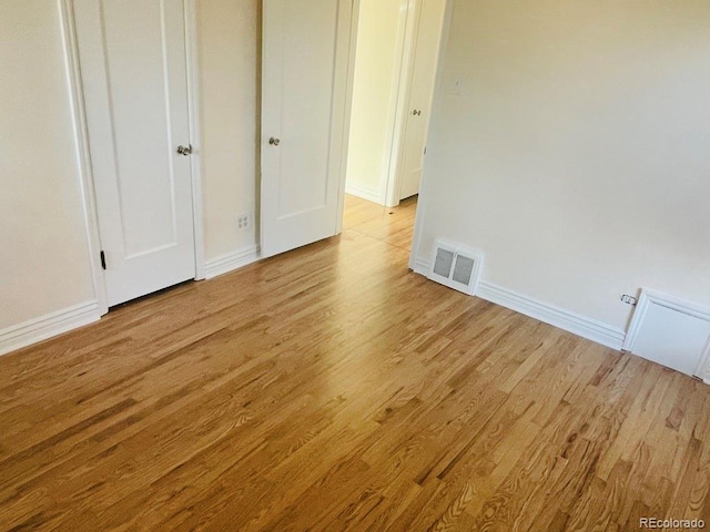 unfurnished bedroom featuring light hardwood / wood-style floors and a closet