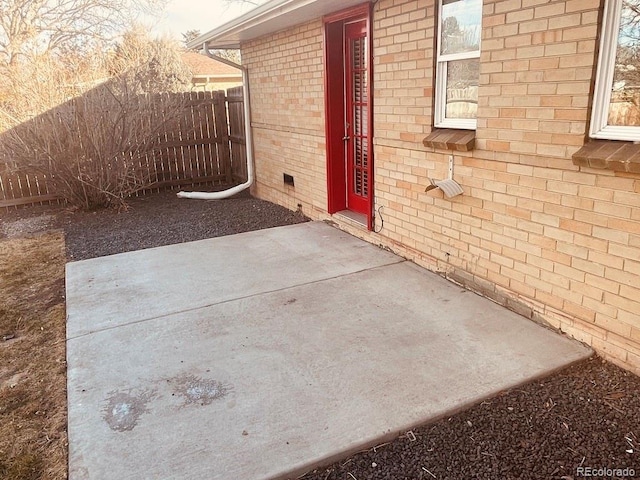 view of exterior entry with a patio