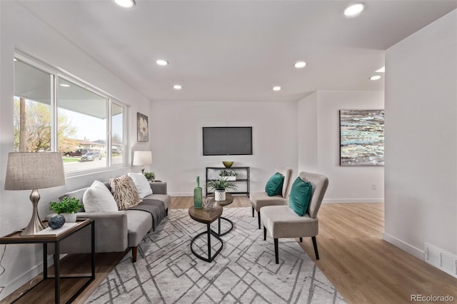 living area with recessed lighting, wood finished floors, and baseboards