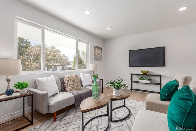 living room with light wood finished floors and recessed lighting