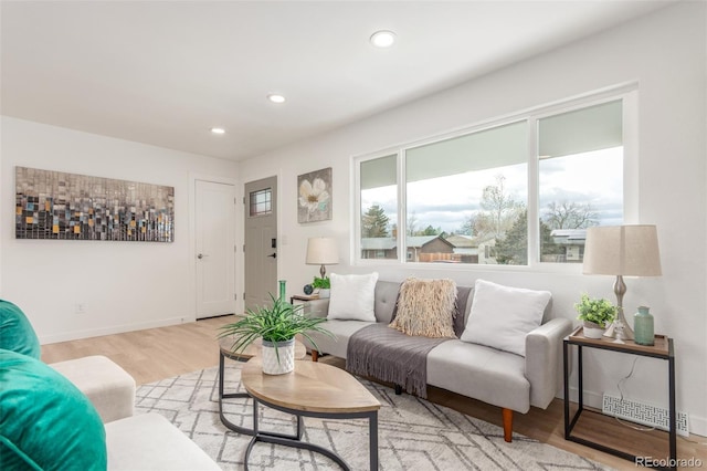 living room featuring light wood-style flooring, recessed lighting, and baseboards
