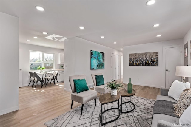 living room featuring light wood finished floors, baseboards, and recessed lighting