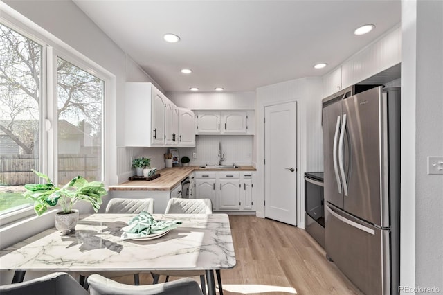 kitchen featuring stainless steel appliances, white cabinetry, light wood-style flooring, light countertops, and recessed lighting
