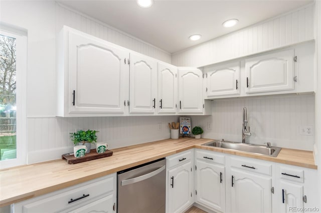 kitchen with stainless steel dishwasher, a sink, wooden counters, white cabinetry, and recessed lighting
