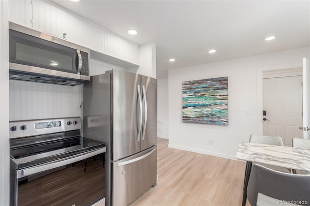 kitchen featuring stainless steel appliances, light wood-style floors, white cabinetry, baseboards, and recessed lighting