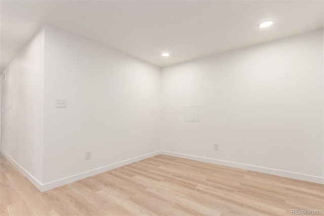empty room featuring recessed lighting, light wood finished floors, and baseboards