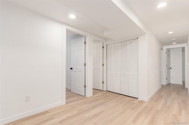 corridor featuring wood finished floors, baseboards, and recessed lighting