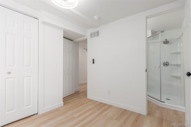 unfurnished bedroom featuring light wood finished floors, a closet, and baseboards