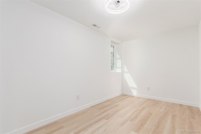 spare room with light wood-type flooring and baseboards
