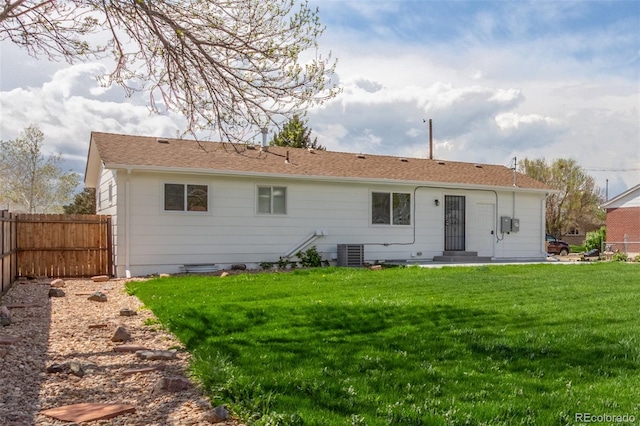 rear view of property with cooling unit and roof with shingles