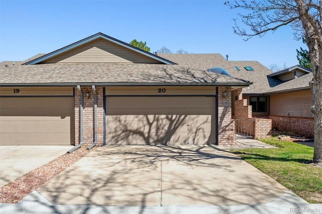 2010 46th Ave Unit 20, Greeley, CO 80634 - view of front of property featuring brick siding, driveway, roof with shingles, and an attached garage