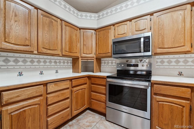 2010 46th Ave Unit 20, Greeley, CO 80634 - kitchen with appliances with stainless steel finishes, decorative backsplash, light countertops, and light tile patterned floors